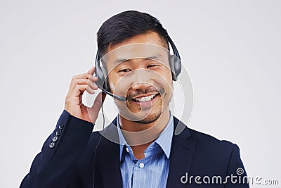 Listening, thinking and Asian man in callcenter with smile, headset and happy in studio. Male person, consultant and Stock Photo