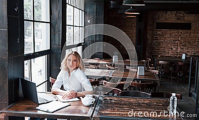 Listens careful to the patient. Businesswoman with curly blonde hair indoors in cafe at daytime Stock Photo