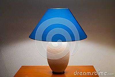 Lit bedside lamp over nightstand Stock Photo