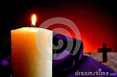 Lit candle and a Christian cross Stock Photo