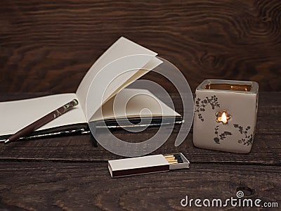 Candle, matches and notebook on a wooden table Stock Photo