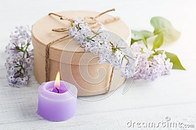 Lit purple candle and lilac flowers Stock Photo