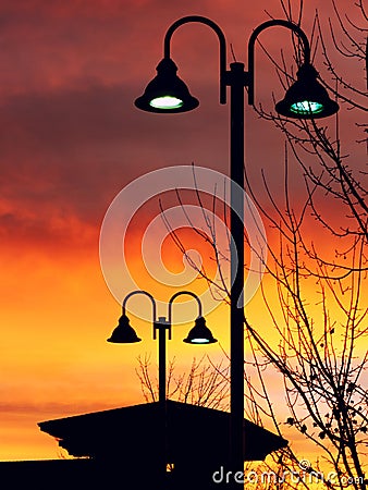 Lit Vertical Lightposts with Sunrise Background Stock Photo