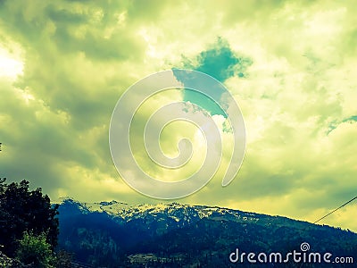 Lite yellow clouds over the snow covered mountains Stock Photo