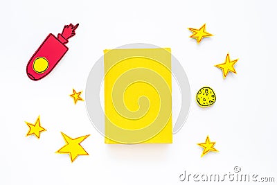 Literature for children. Fantactic, fiction story. Book with blank cover near cutout of rocket, stars, moon on white Stock Photo