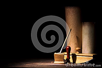 Literature and poetry concept. Old inkstand with fountain pen, blotter, seal near scrolls against black background. Dramatic light Stock Photo