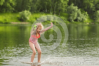 Litle girl playing in the water and making splash Stock Photo
