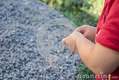 A litlle child playing with stones on the mountain with stones Stock Photo