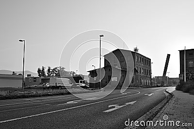 Litomerice, Czech republic - May 19, 2018: asphalt road leading around old historical industrial building and parked cars to shopp Editorial Stock Photo