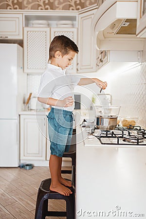 Litte boy cooking melt chocolate on the kitchen Stock Photo