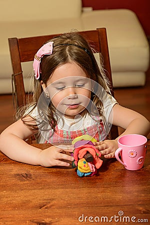 Littel girl playing indoor with clay Stock Photo