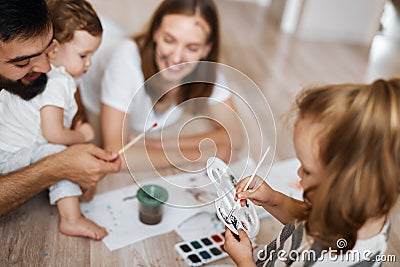 Little adorable blonde girl holding pallet and mixing colours Stock Photo