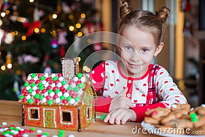 Little adorable girl with decorating gingerbread Stock Photo