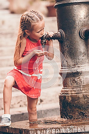 Little girl having fun with drinking water at street fountain in Rome, Italy Stock Photo