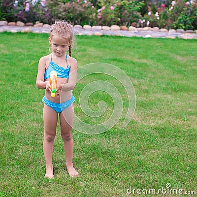 Little adorable girl playing with water gun Stock Photo