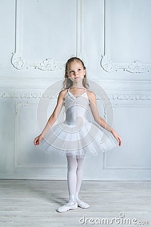 A little adorable young ballerina isposing on camera in the interior studio Stock Photo