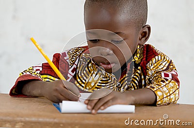 Little African Black Baby Boy in the Classroom Writing Notes Stock Photo