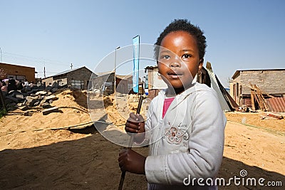 Little African Girl playing in the backyard building site in a Soweto Township Editorial Stock Photo