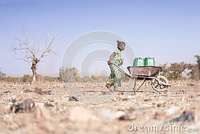 Little African Woman Transporting Fresh Water as a drought symbol Stock Photo