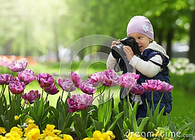 Little amateur photographer is happy and surprised by the quality to take the picture with the help of the professional camera Stock Photo