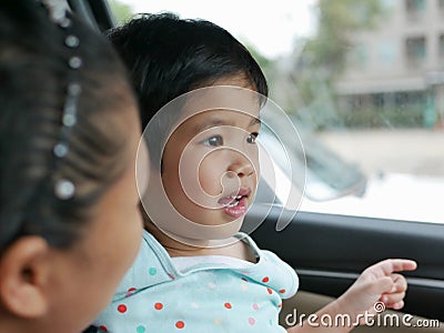 Little Asian baby girl having fun traveling with her mother by car as she learning to tell what she see during the trip Stock Photo