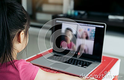 Little asian girl attending to online e-learning platform class from home while school has been closed during coronavirus outbreak Stock Photo