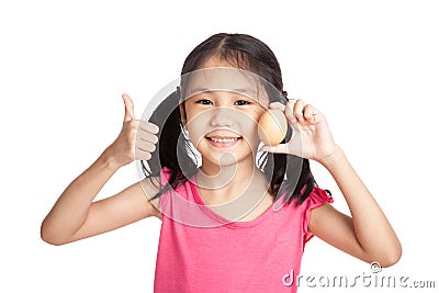 Little asian girl thumbs up with an egg in hand Stock Photo