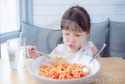 Girl with unhappy face while having fried spaghetti Stock Photo