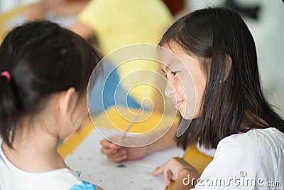 Little asian girl writing in the notebook school Stock Photo