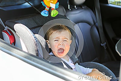 Little baby boy is crying in his car seat not willing to sit in it. Stock Photo