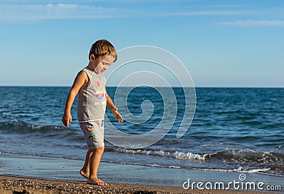 Little baby boy running along the coast of the sea. Positive human emotions, feelings, Stock Photo