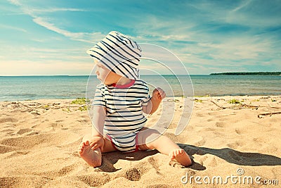 Little baby boy sitting on the beach in summer day Stock Photo