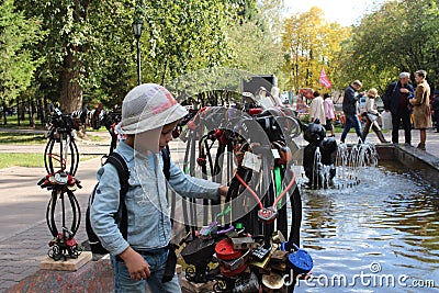 Little baby boy walking considering the decorations on the decorative railing of the fountain in the first square in Novosibirsk Editorial Stock Photo