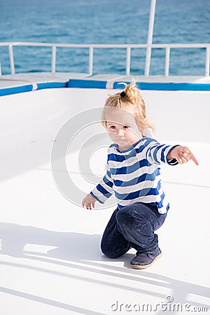 Little baby captain on boat on summer cruise, nautical fashion Stock Photo