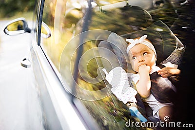 Little baby fastened with security belt in safety car seat. Stock Photo