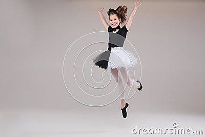 Little baby girl ballerina dancing in black and white clothing smiling having positive emotion Stock Photo