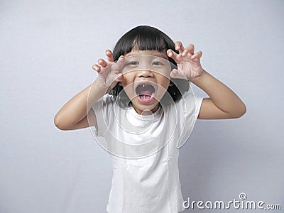 Little Baby Girl Doing Tiger Roar Gesture Stock Photo