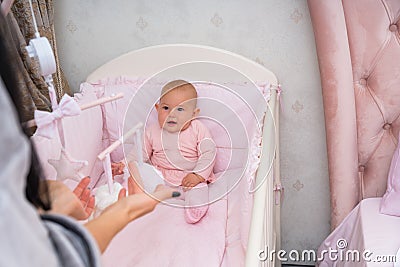 Little baby girl watching a hanging mobile. Stock Photo
