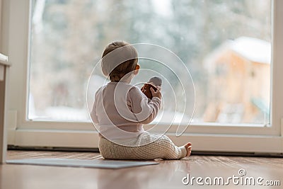 Little baby girl watching the snow outdoors Stock Photo