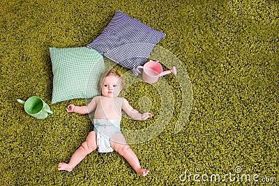 Little baby lies on green carpet Stock Photo