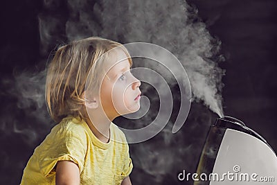 Little baby looks at the humidifier Stock Photo