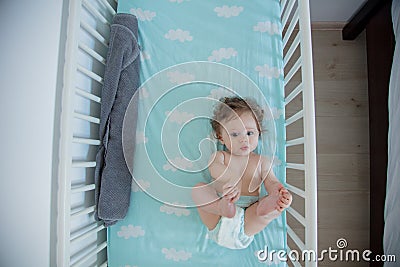 Little baby lying down in a bed at home Stock Photo