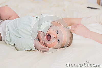 Little baby with open mouth cute lies on the bed Stock Photo