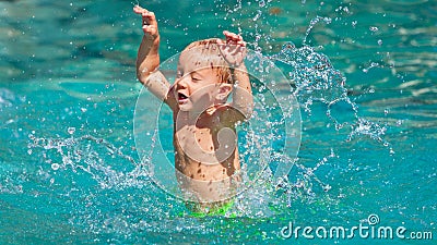 Little baby splashing with fun in beach swimming pool Stock Photo