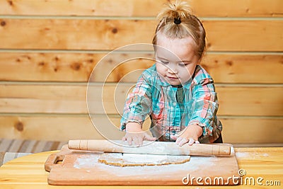 Little baker child at kitchen. Baby boy in the kitchen helping with cooking, playing with flour. Stock Photo