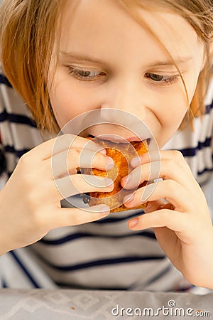 Little baker's delight: A child relishing a homemade puff pastry, a small bite of love in every morsel Stock Photo