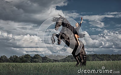 Little ballerina girl with black friesian stallion Stock Photo