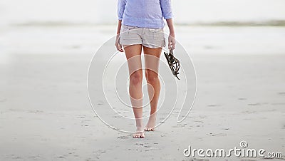 A little beach stroll. the bottom half of a woman walking along the beach. Stock Photo