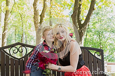 Little beautiful boy gives flowers to mom. Stock Photo