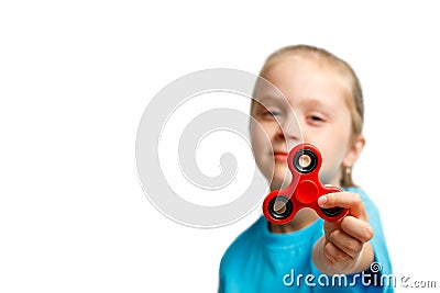 Little beautiful girl in blue t-shirt is playing red spinner in hand Stock Photo